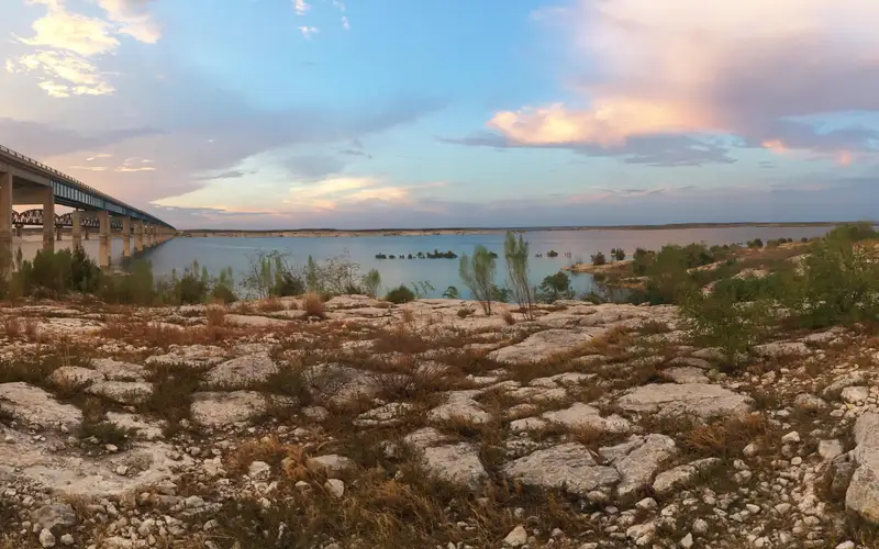 Sunset over Amistad Reservoir with Highway 90 bridge to left of photo going over the reservoir and i