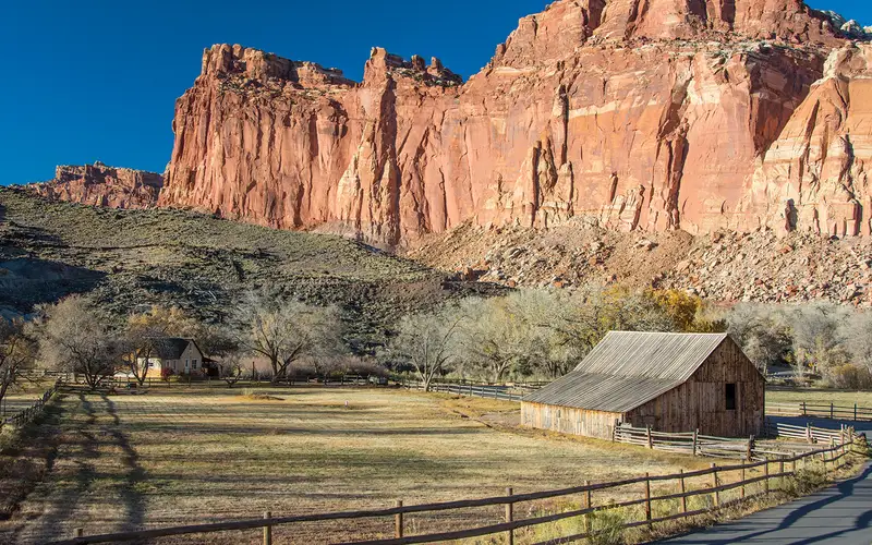 Wingate Sandstone cliffs behind historic barn and farmhouse