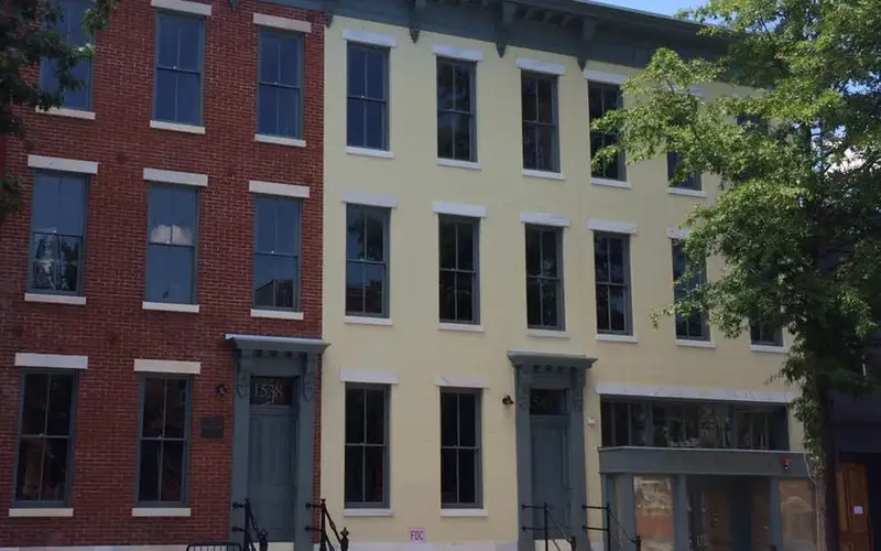 The restored facades of three historic Victorian row-homes on an urban street in Washington, DC