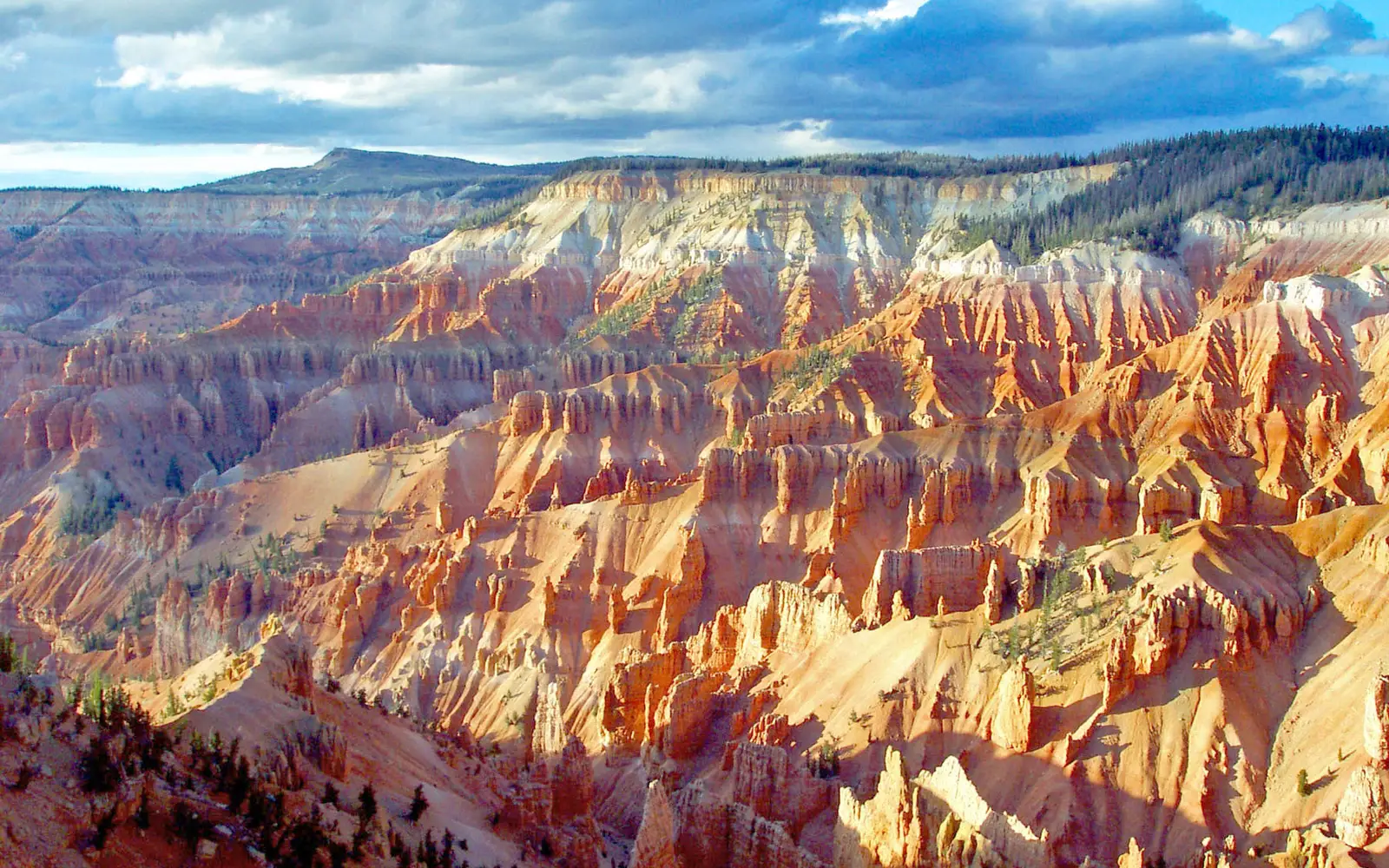 The ground falls away from the viewer creating brilliant rock formations of pink, red, and orange.