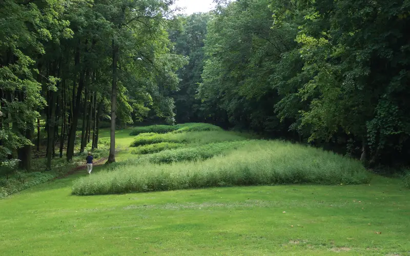Bear Effigy Mounds with visitor walking nearby.