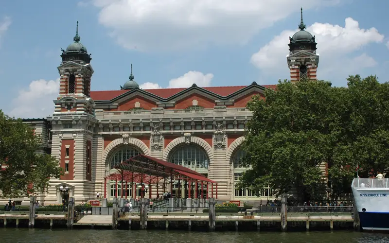 Beaux-Arts brick and limestone building with large arched windows and cupola-topped towers.