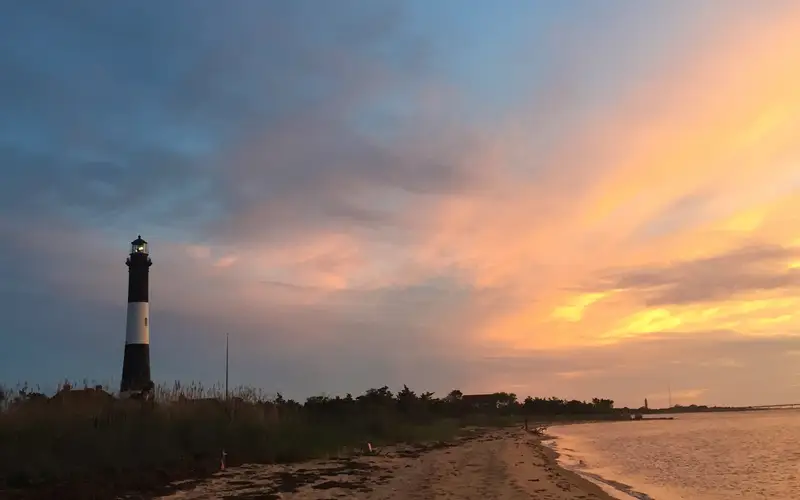 The Fire Island Lighthouse against a vibrant sunset.