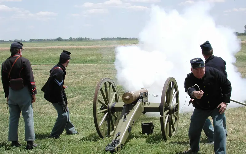 Men in 19th century U.S. Army uniforms fire a reproduction period cannon.