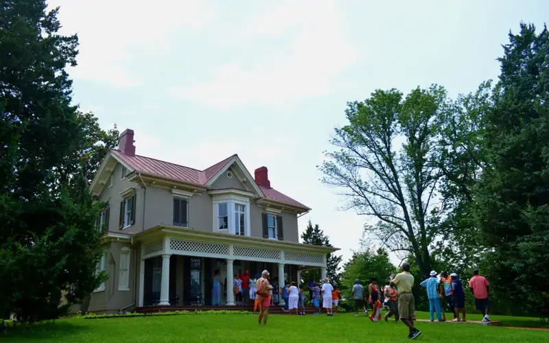 Visitors take photos in front of a historic house