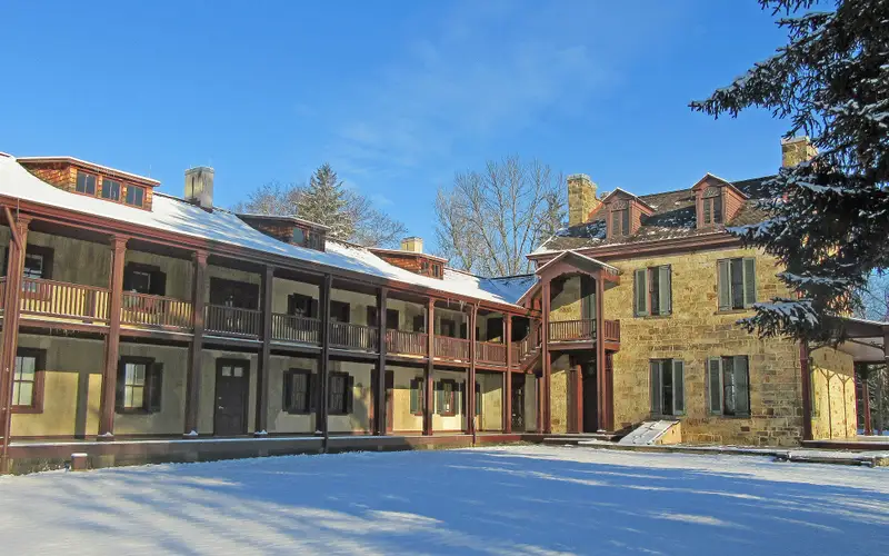 Gallatin House - Stone House and South Wing in snow with blue sky