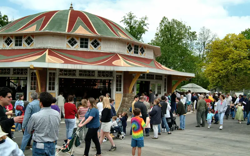 groups of families, adults and children strolling in Glen Echo Park near Carousel Building