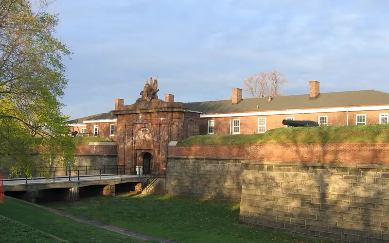 Bridge over dry moat leading into a gated fort.
