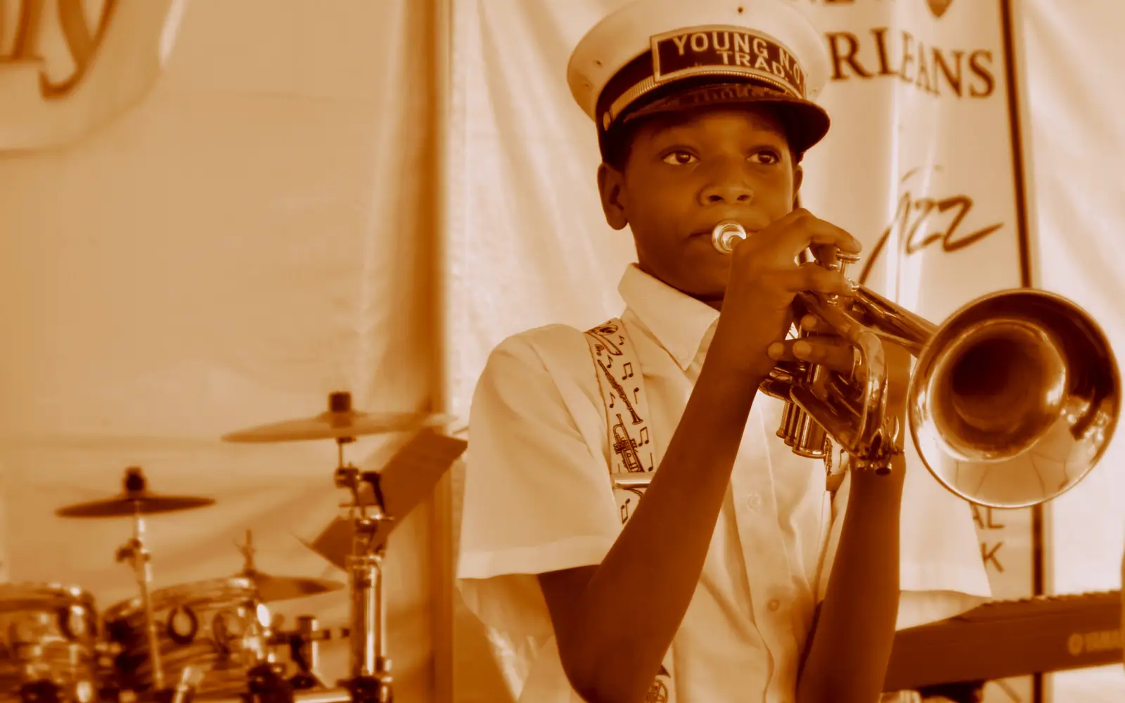 A young brass band musician plays a trumpet