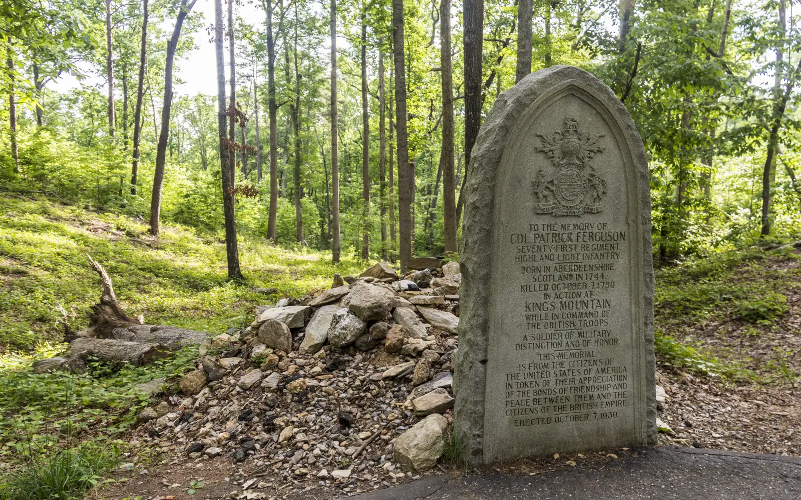 An oval gravestone for Maj Patrick Ferguson is in front of his stone covered grave.