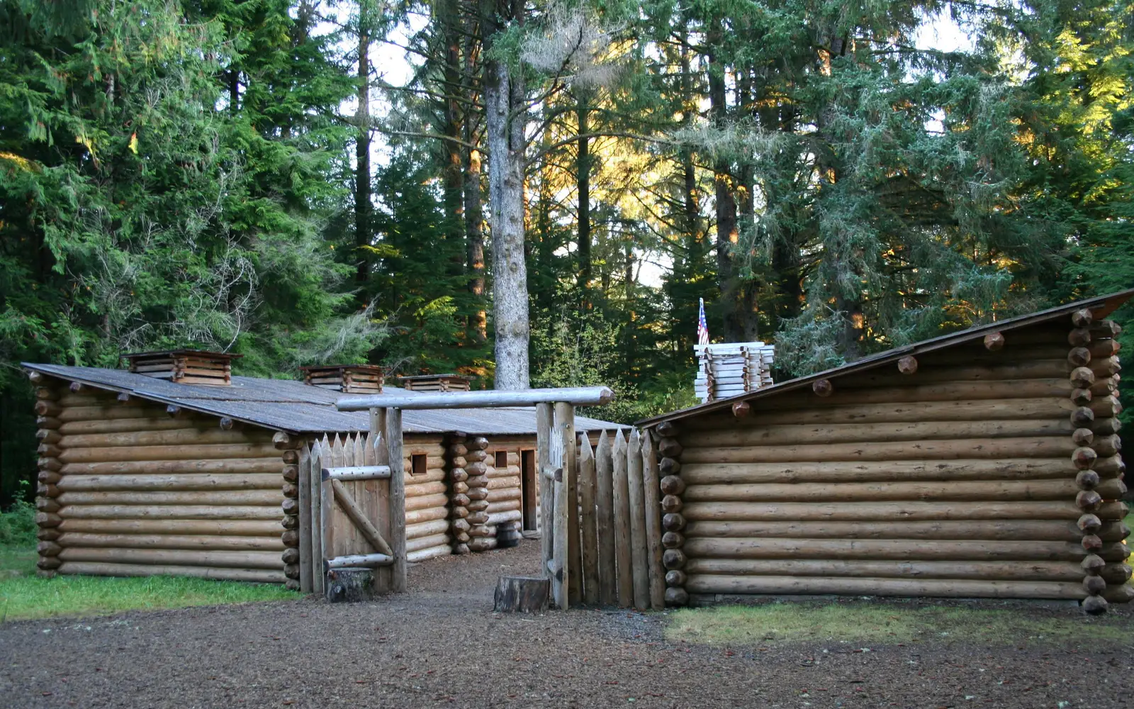A fifty foot square wooden fort surrounded by tall trees in a forest.