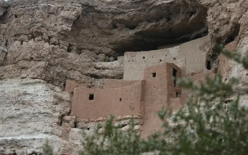 A 5-story masonry dwelling sits in a cliff alcove.