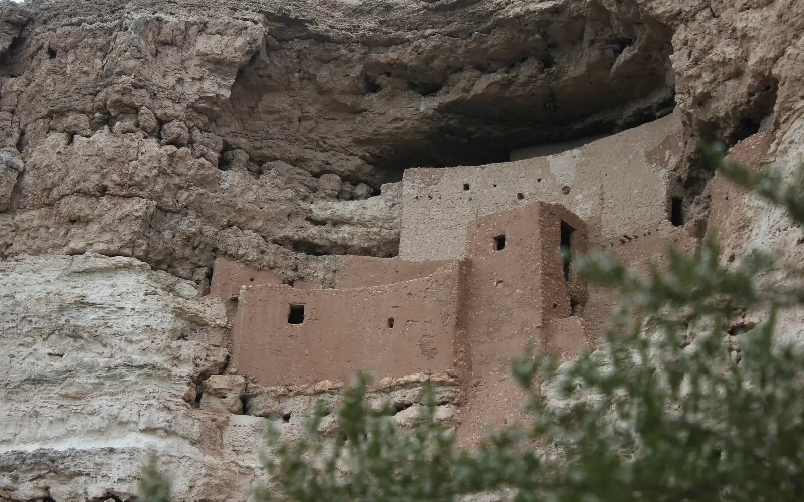 A 5-story masonry dwelling sits in a cliff alcove.
