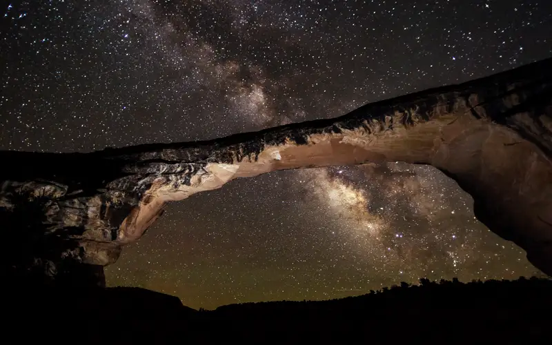 a natural bridge at night with the Milky Way arcing overhead