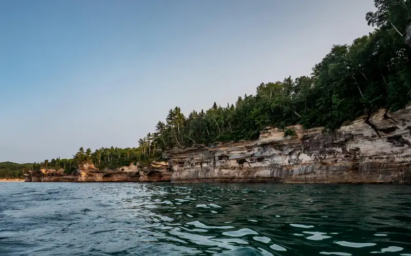 Multi-colored sandstone cliffs rise out of Lake Superior