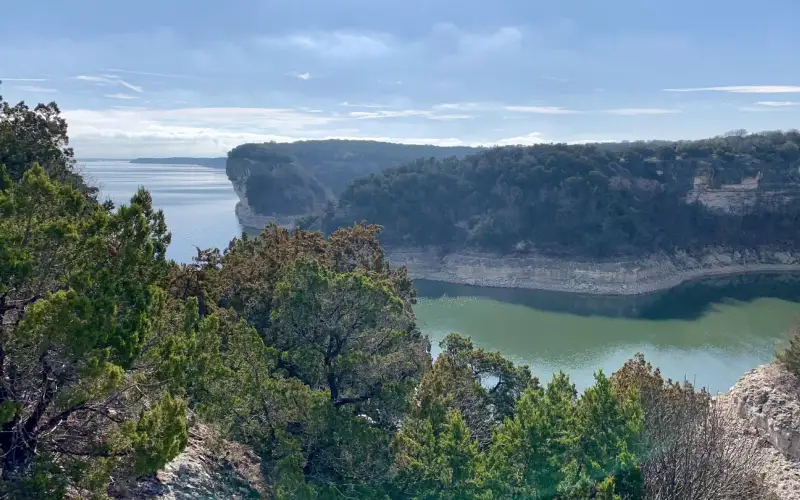 Limestone bluffs covered with ashe juniper trees surrounding Whitney Lake.