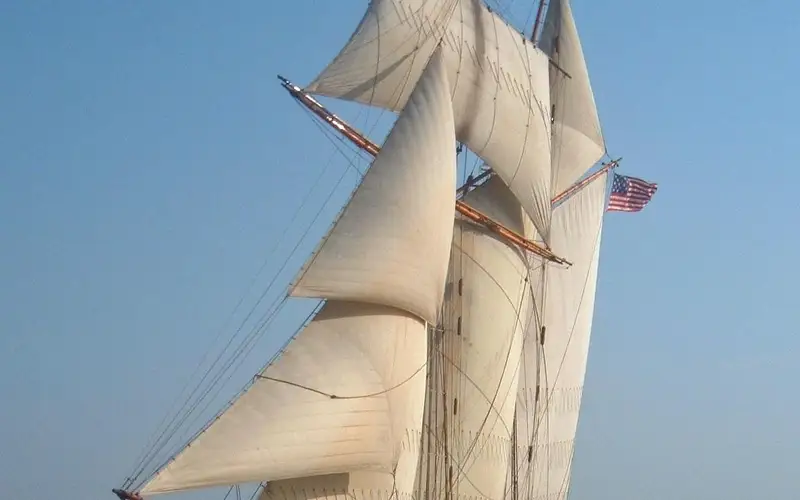 A tall ship sails on the water.