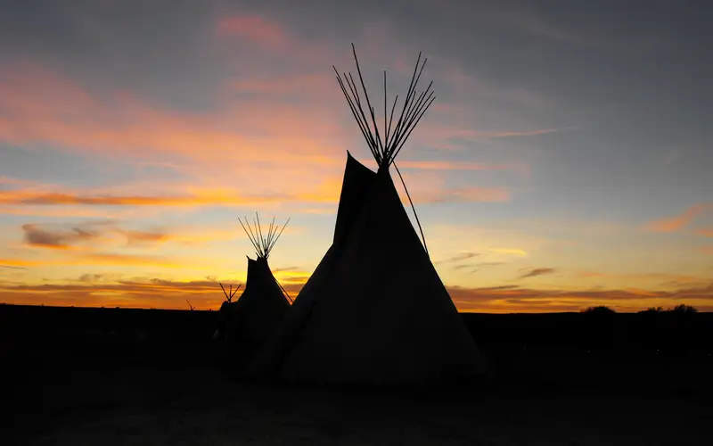 Cheyenne tipis backlite by sunset