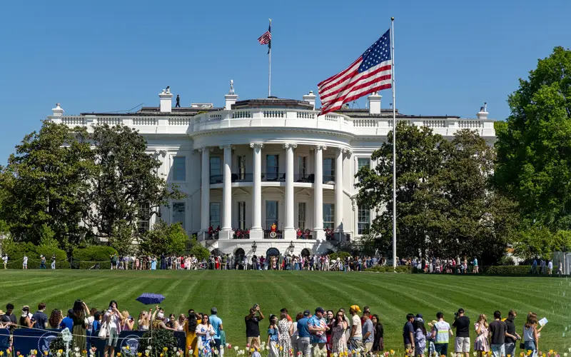 Crowds of people populate the White House South Lawn on a sunny day with the White House in view