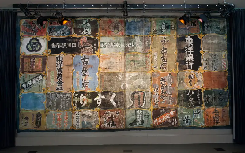 theatre curtain painted with Japanese characters advertising local businesses